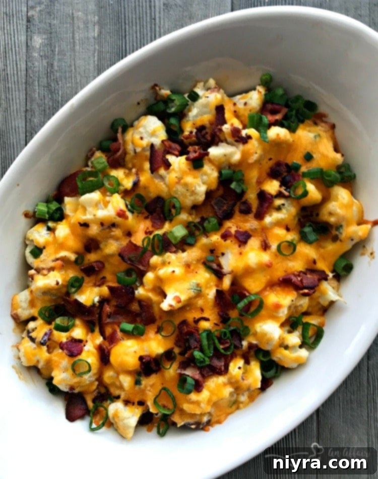 Close-up of a serving of Loaded Cauliflower Casserole, showing the creamy texture and toppings