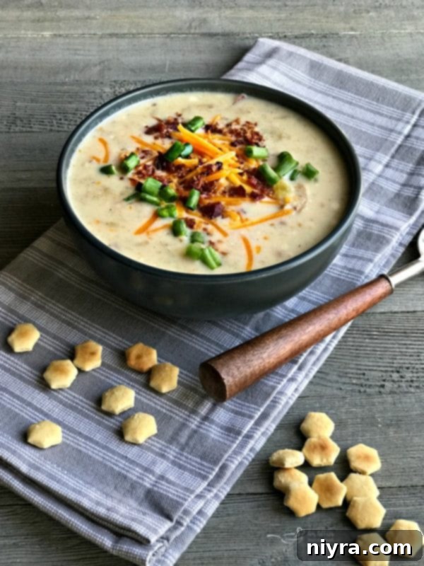 Instant Pot Loaded Potato Soup with red and gold baby potatoes, skins on, topped with bacon, cheese, and green onions.