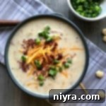 close up of Loaded Potato Soup in a dark bowl