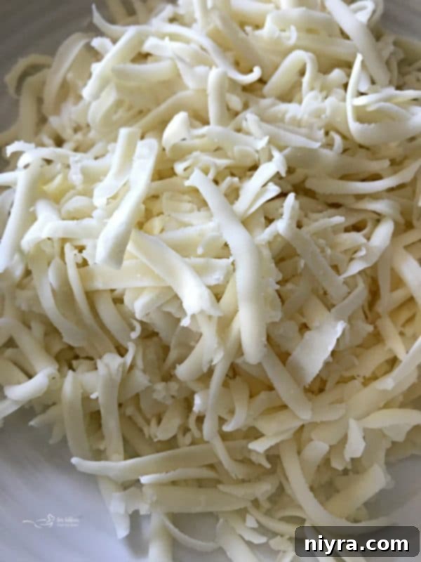 Cheesesteak soup topped with melted provolone cheese, ready to serve.