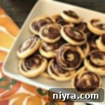 A beautifully presented close-up of a single Pumpkin Spice Swirl cookie on a white plate