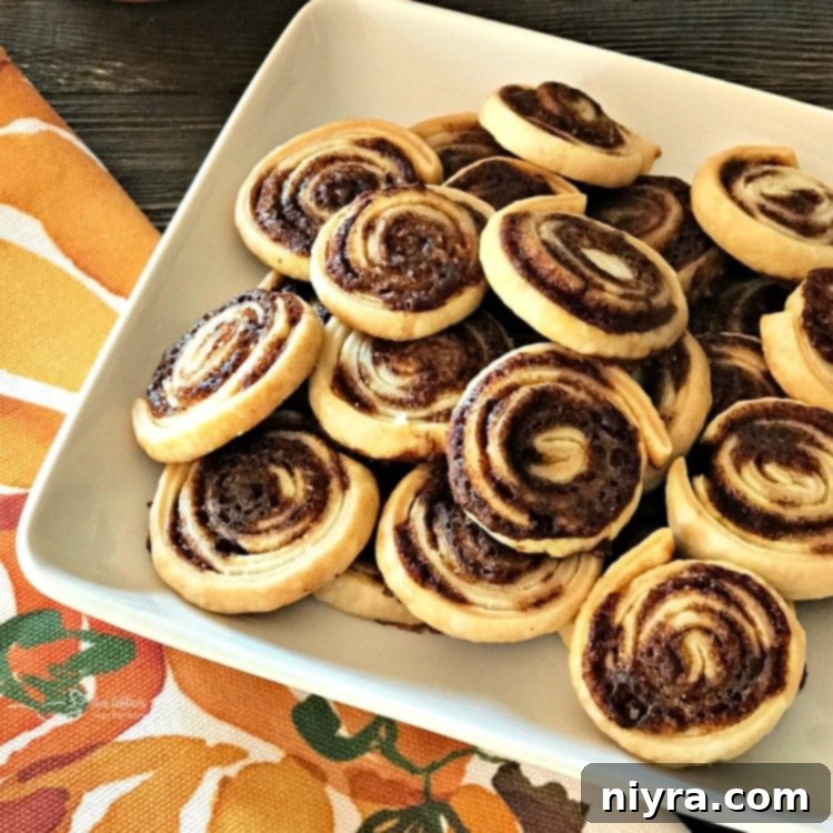 A baking sheet filled with freshly baked, golden and glistening Pumpkin Spice Swirl cookies