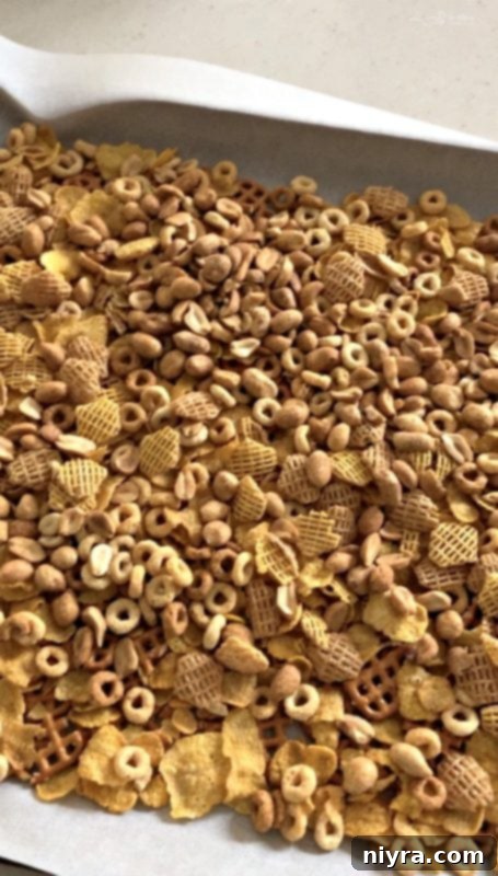 Monster Mash Snack Mix 5 Preparing Halloween White Trash Mix by layering ingredients on a sheet pan