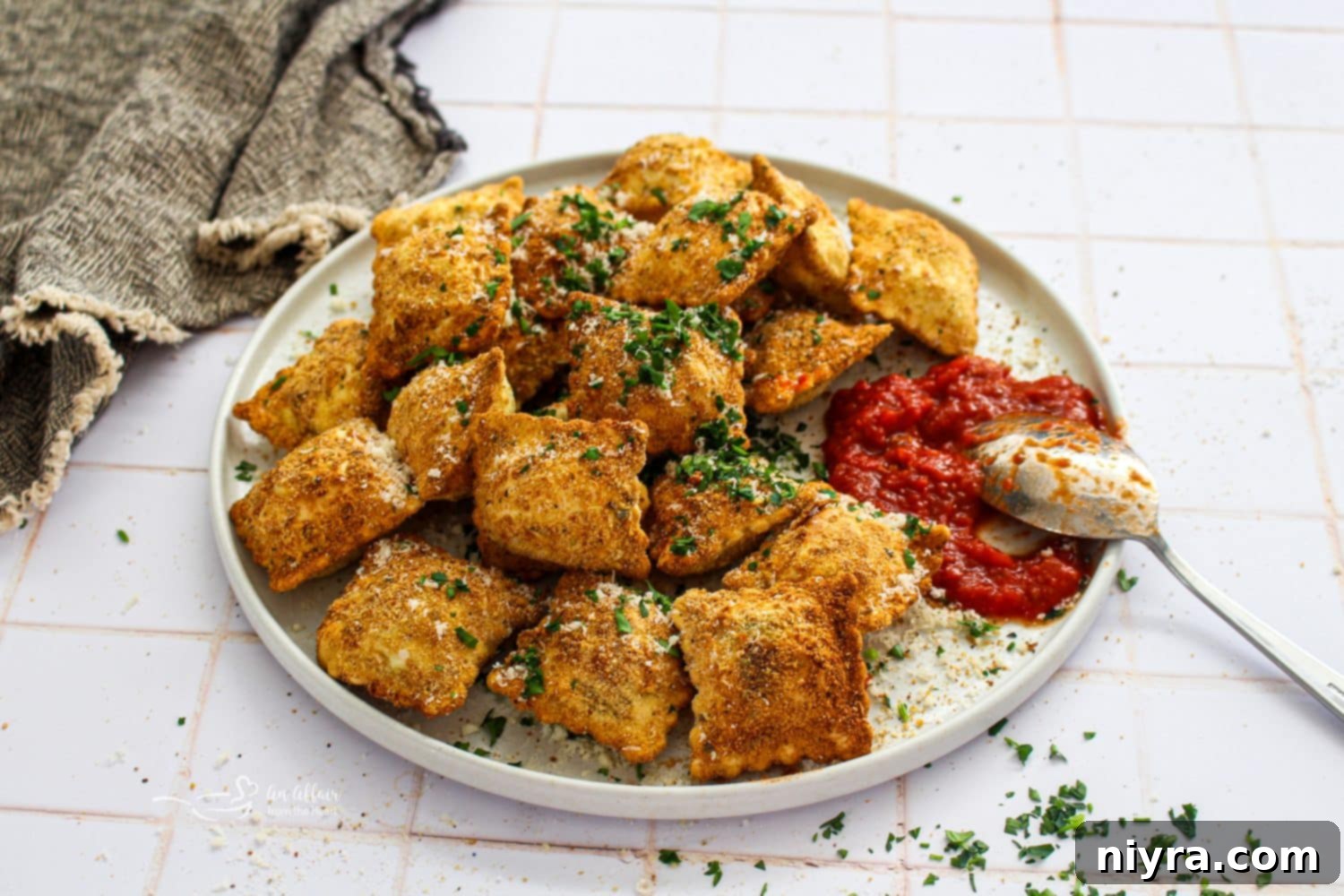Crispy Air Fryer Toasted Ravioli on a plate with marinara sauce.