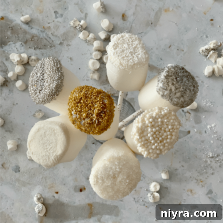 White chocolate-dipped marshmallows drying upside down on a baking sheet
