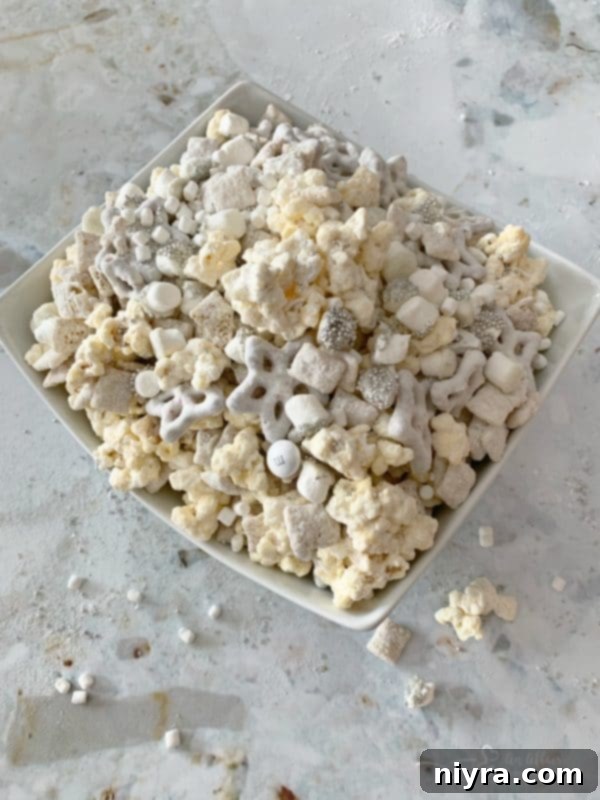 Winter Wonderland Snack Mix in a clear bowl, displaying its beautiful texture and festive sprinkles