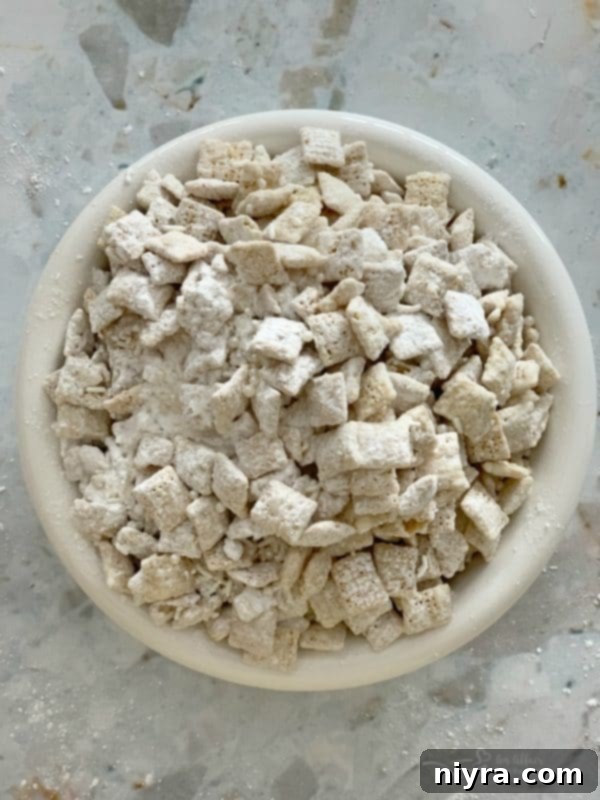 Close-up of white chocolate-covered Chex cereal with sprinkles, part of the Winter Wonderland Snack Mix