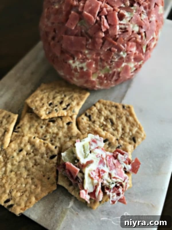 Dill Pickle Wrap Cheese Ball served on a cracker
