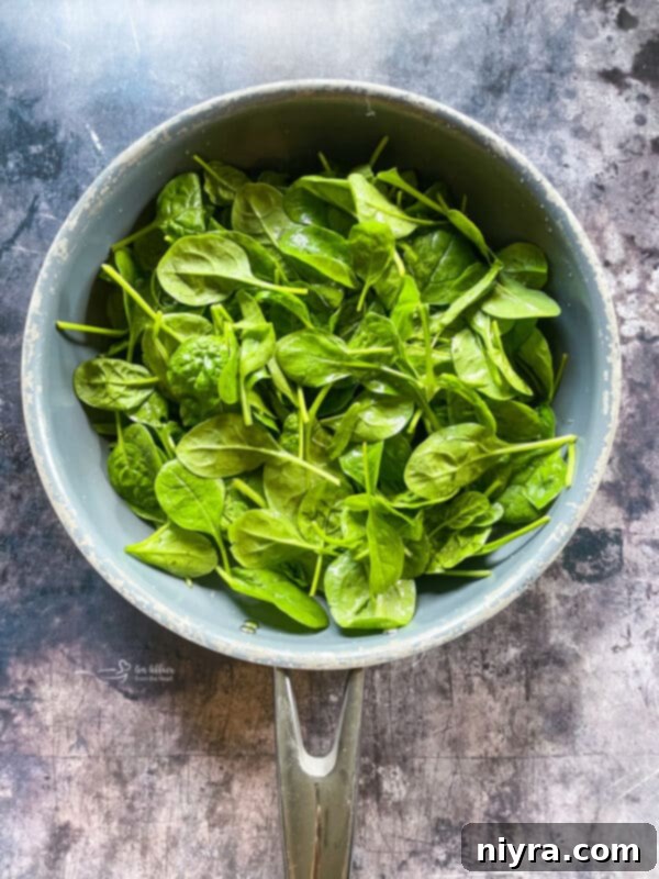 Fresh spinach in a bowl, ready to be wilted