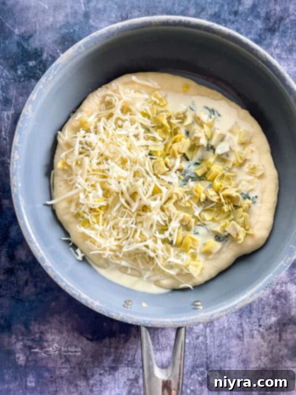 Spinach Artichoke Alfredo Pizza baking in the oven
