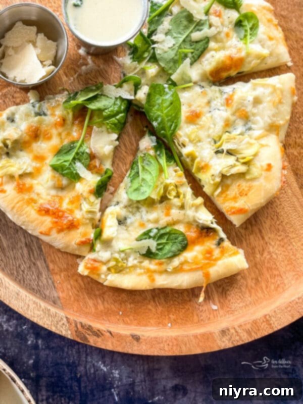 Cutting and serving Spinach and Artichoke Alfredo Pizza
