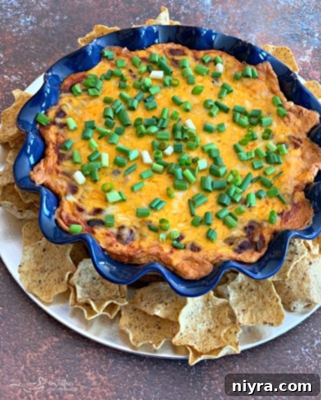 Warm Chili Cheese Bean Dip in a white pie plate