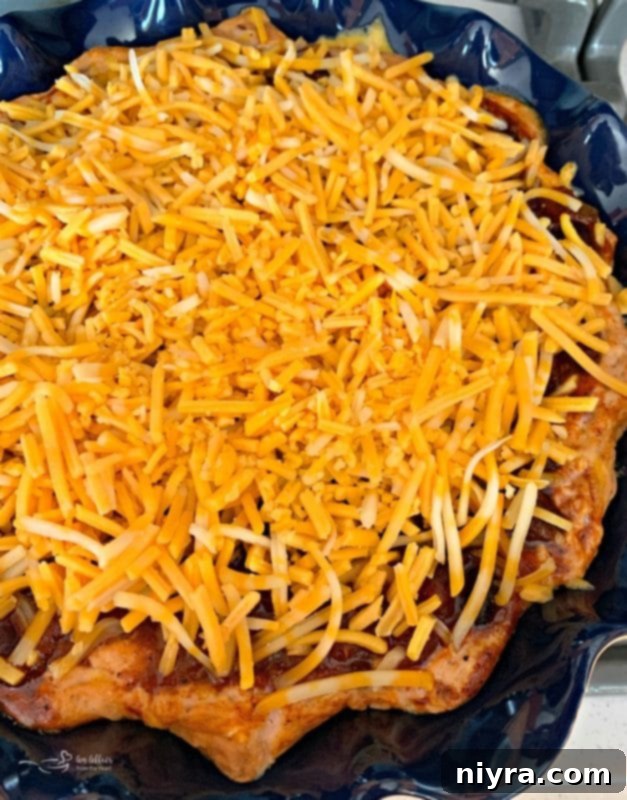Chili Cheese Bean Dip baking in the oven with the final layer of cheese just added