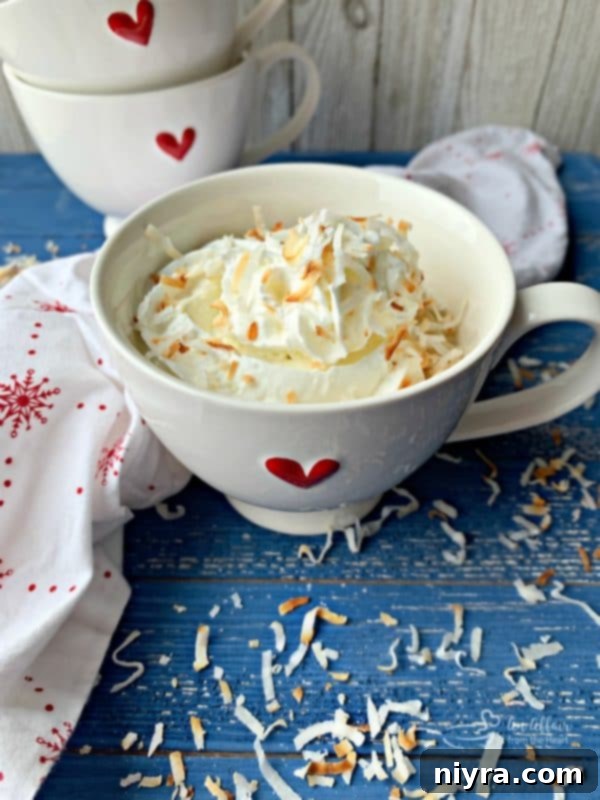 Deliciously moist Coconut Mug Cake topped with whipped cream and toasted coconut flakes