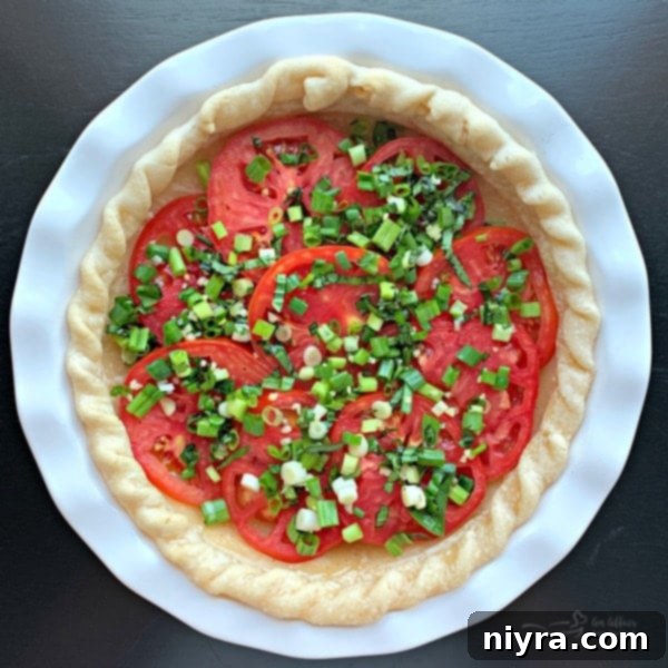 Tomatoes in pie crust topped with green onions and basil