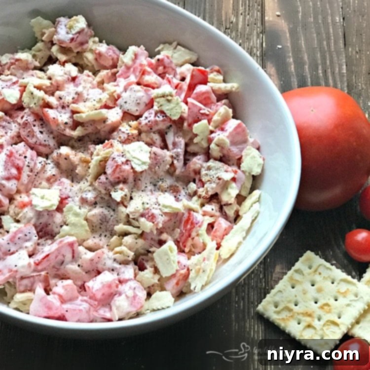 Tomato Cracker Salad served in a rustic white bowl on a wooden surface, ready to eat.