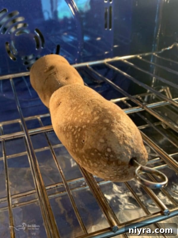 Potatoes baking in the oven on stainless steel skewers