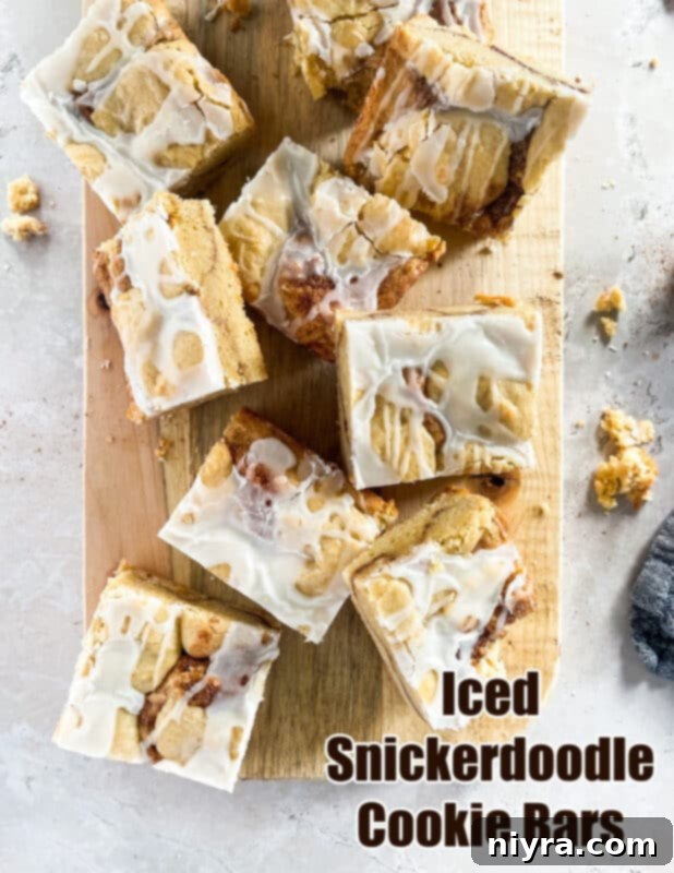 A stunning hero shot of a full pan of glazed Iced Snickerdoodle Cookie Bars, freshly baked and ready to be cut.