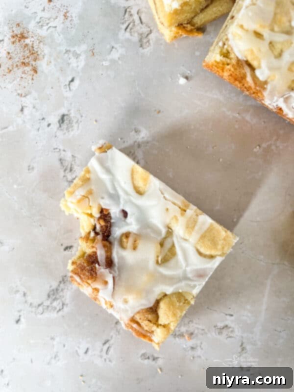 Close-up of Iced Snickerdoodle Bars, showcasing the texture and a generous drizzle of vanilla glaze.