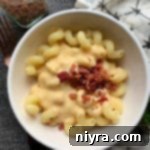 Crafted Beer Cheese Pasta 11 Overhead of Beer Cheese Pasta Sauce with bacon in a white bowl