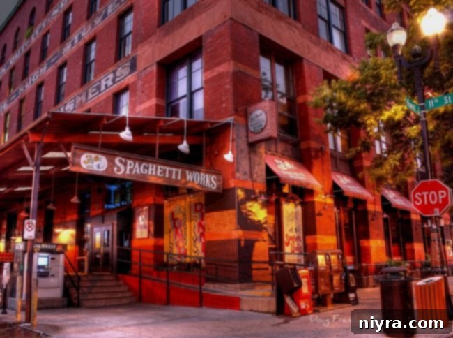 Crafted Beer Cheese Pasta 3 A vibrant street scene of Omaha's historic Old Market, featuring the charming facade of Spaghetti Works restaurant under a clear sky.