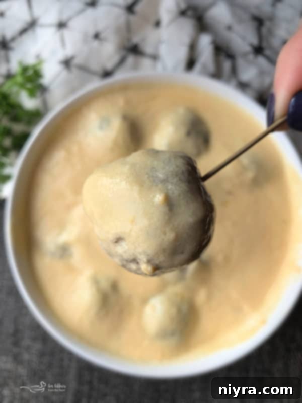 Crafted Beer Cheese Pasta 5 Homemade Italian meatballs generously covered in creamy Beer Cheese Pasta Sauce, showcasing a delicious appetizer or pasta topping.