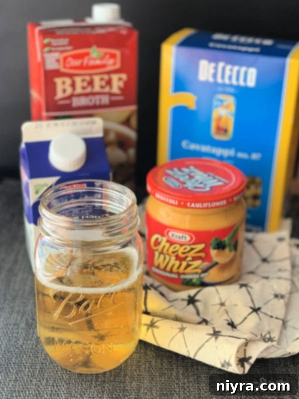 Crafted Beer Cheese Pasta 6 All the essential ingredients for making Beer Cheese Pasta Sauce laid out on a clean surface: Half & Half, beer, Cheez Whiz, beef broth, butter, and flour.