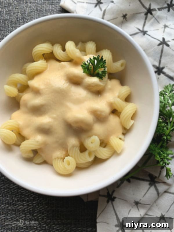 Crafted Beer Cheese Pasta 7 Creamy Beer Cheese Pasta Sauce generously poured over cooked pasta, garnished with fresh parsley, ready to be served.