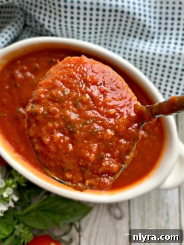Simple Homemade Marinara Sauce being served in a ladle, highlighting its rich texture
