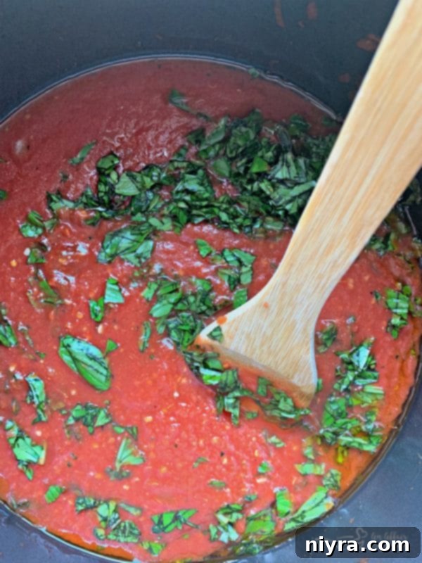 Prepping ingredients for Homemade Marinara Sauce in a pot, showing fresh garlic and onion