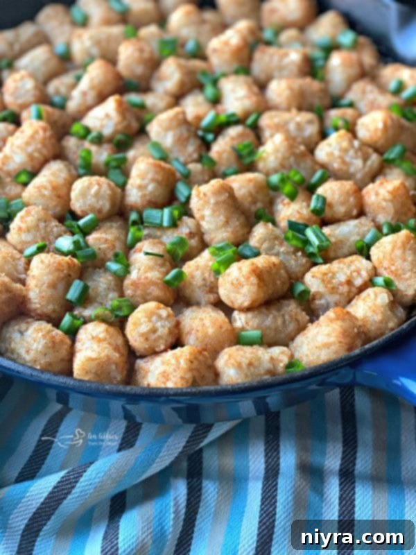Hearty Beef and Sauerkraut Tater Tot Casserole 7 Beef and Kraut casserole with tater tots and Swiss cheese layered in a cast iron skillet, ready for baking.