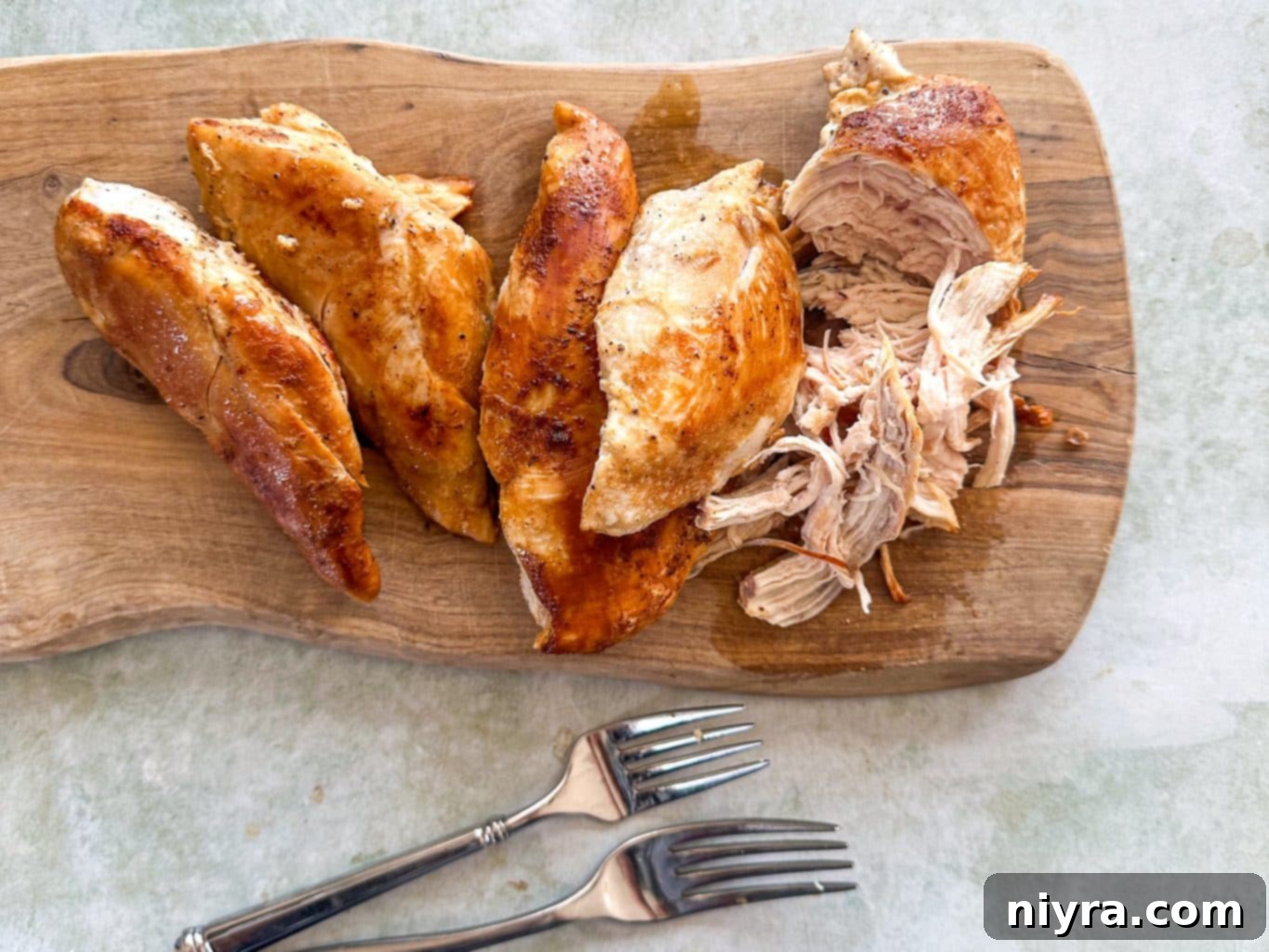 Cooked chicken breasts in a pan, ready to be shredded.