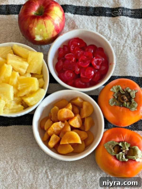 Close-up of ingredients for Persimmon Salad being prepped on a cutting board, including diced persimmons, apples, and dried apricots.