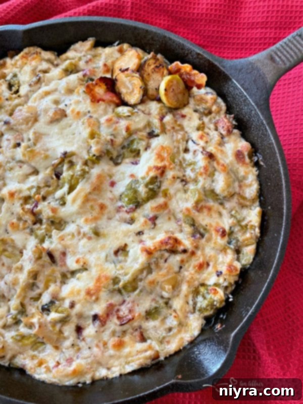 Hot Cheesy Brussels Sprouts Dip overflowing with bacon and cheese, served with crispy pita chips, featuring Paisley Farm Dilled Brussels Sprouts