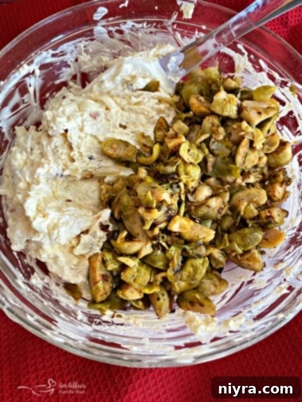 Combining sautéed Brussels sprouts mixture with the cheesy bacon base for the dip