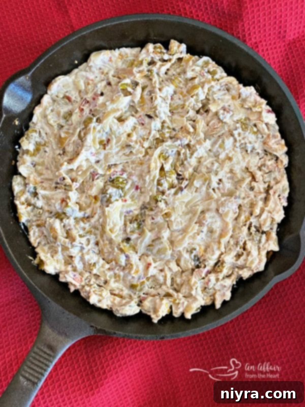 Spreading the Cheesy Brussels Sprouts Dip mixture into a baking dish before baking