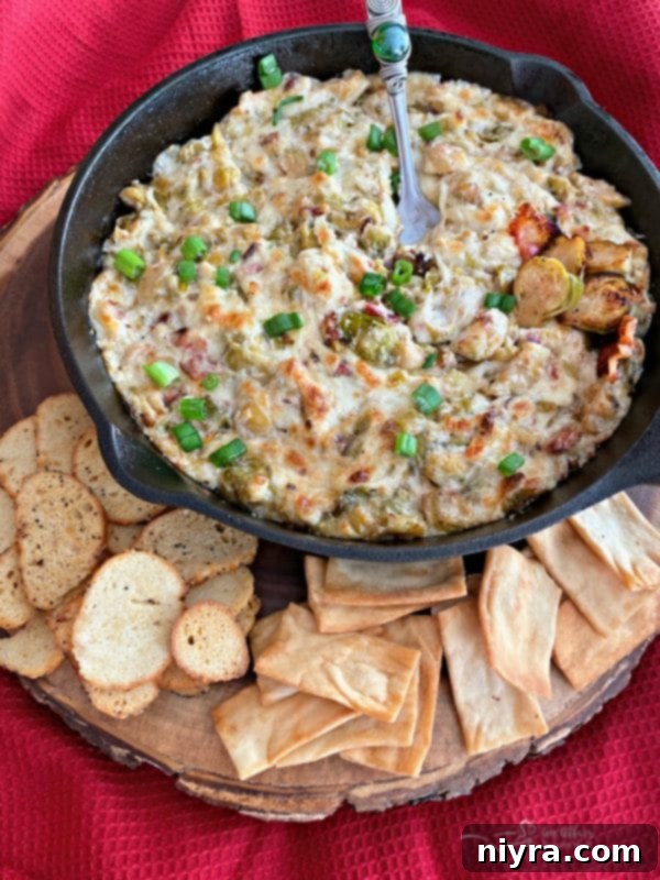 Cheesy Brussels Sprouts Dip served with crispy pita and bagel chips, perfect for dipping