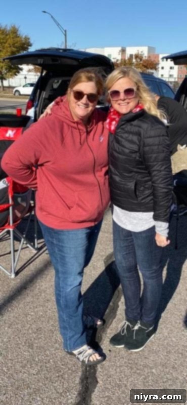 Two friends, one in flip-flops and one in a winter coat, smiling together.