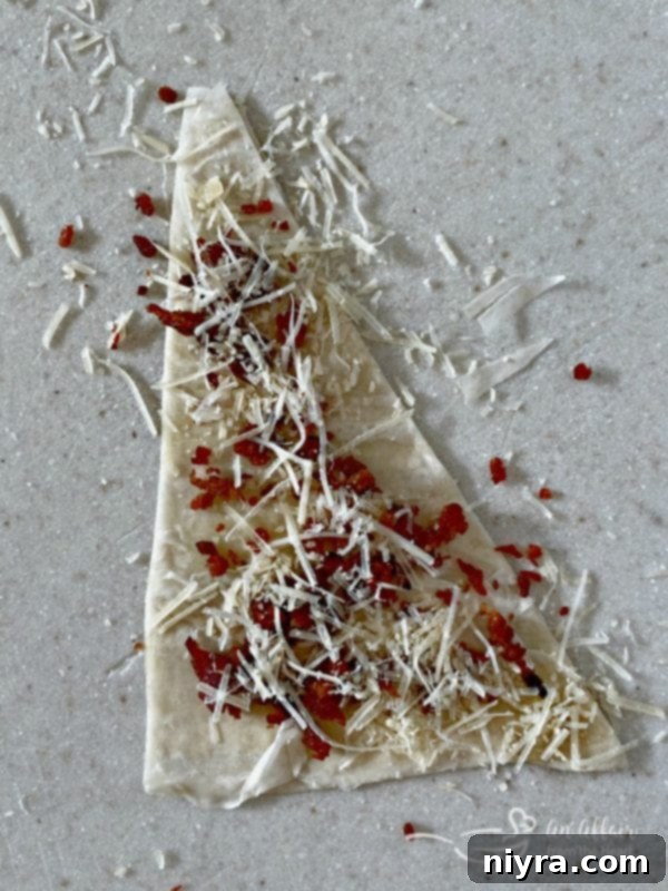 Sprinkling bacon and cheese on phyllo triangles