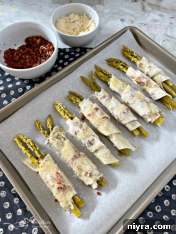 Sealing and arranging phyllo wrapped asparagus on a baking sheet