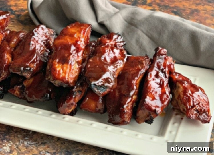 Fall-off-the-bone Slow Cooker Dr. Pepper BBQ Ribs, glazed with a sticky, caramelized sauce.