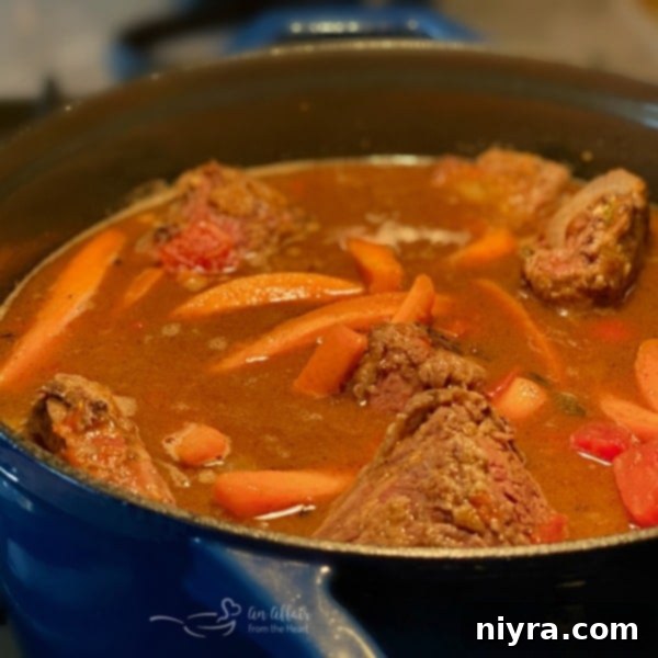 Browned beef short ribs nestled in a rich gravy in a Dutch oven, ready for braising