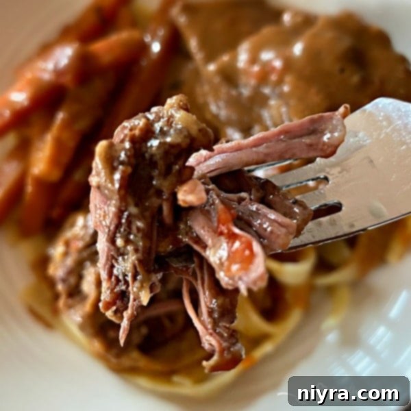 A close-up of a bite of incredibly tender Braised Beef Short Ribs