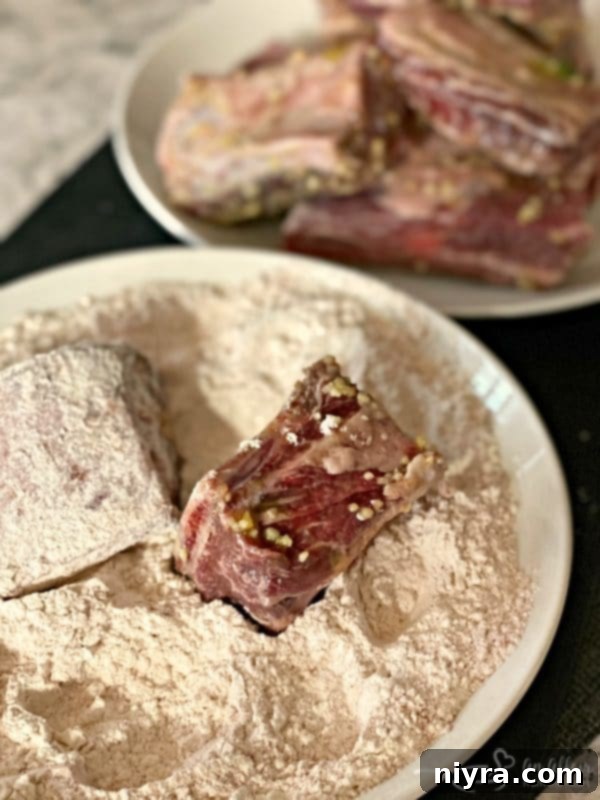Beef Short Ribs being dredged in seasoned flour