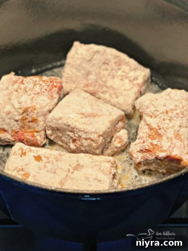 Beef Short Ribs searing in a cast-iron Dutch oven