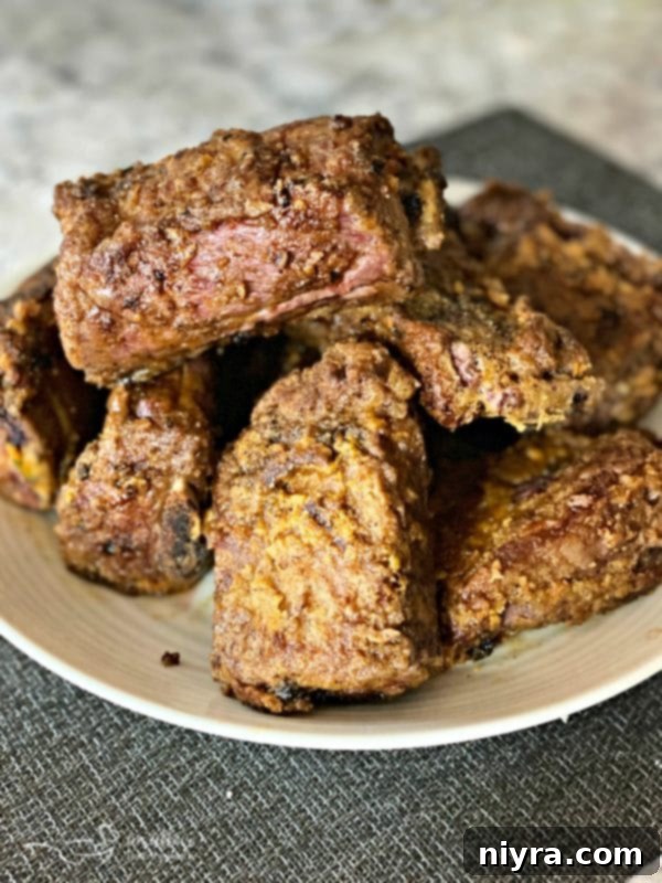 Sizzling beef short ribs searing to a golden brown in a Dutch oven