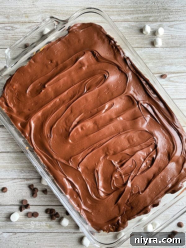 Homemade Whatchamacallit Bars cooling in a pan after the chocolate topping has been applied