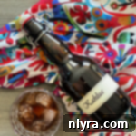 bottle of homemade kahlua next to a glass that is full of kahlua