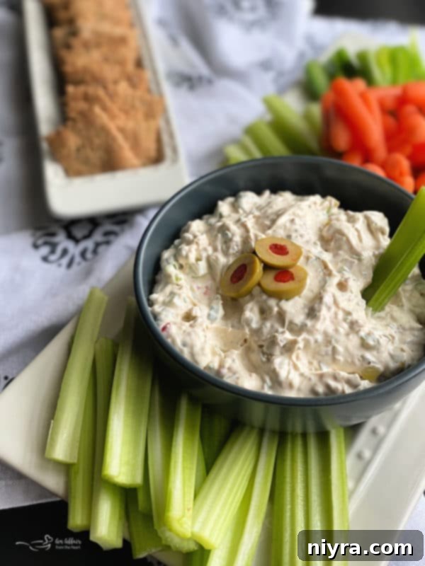 A close-up shot of creamy olive dip garnished with sliced olives, ready for serving.