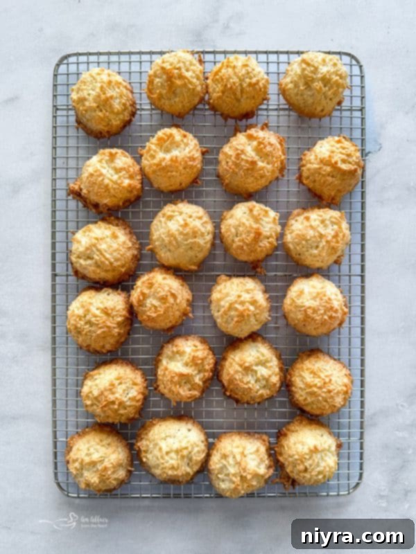 Freshly baked golden-brown coconut macaroons cooling on a wire rack